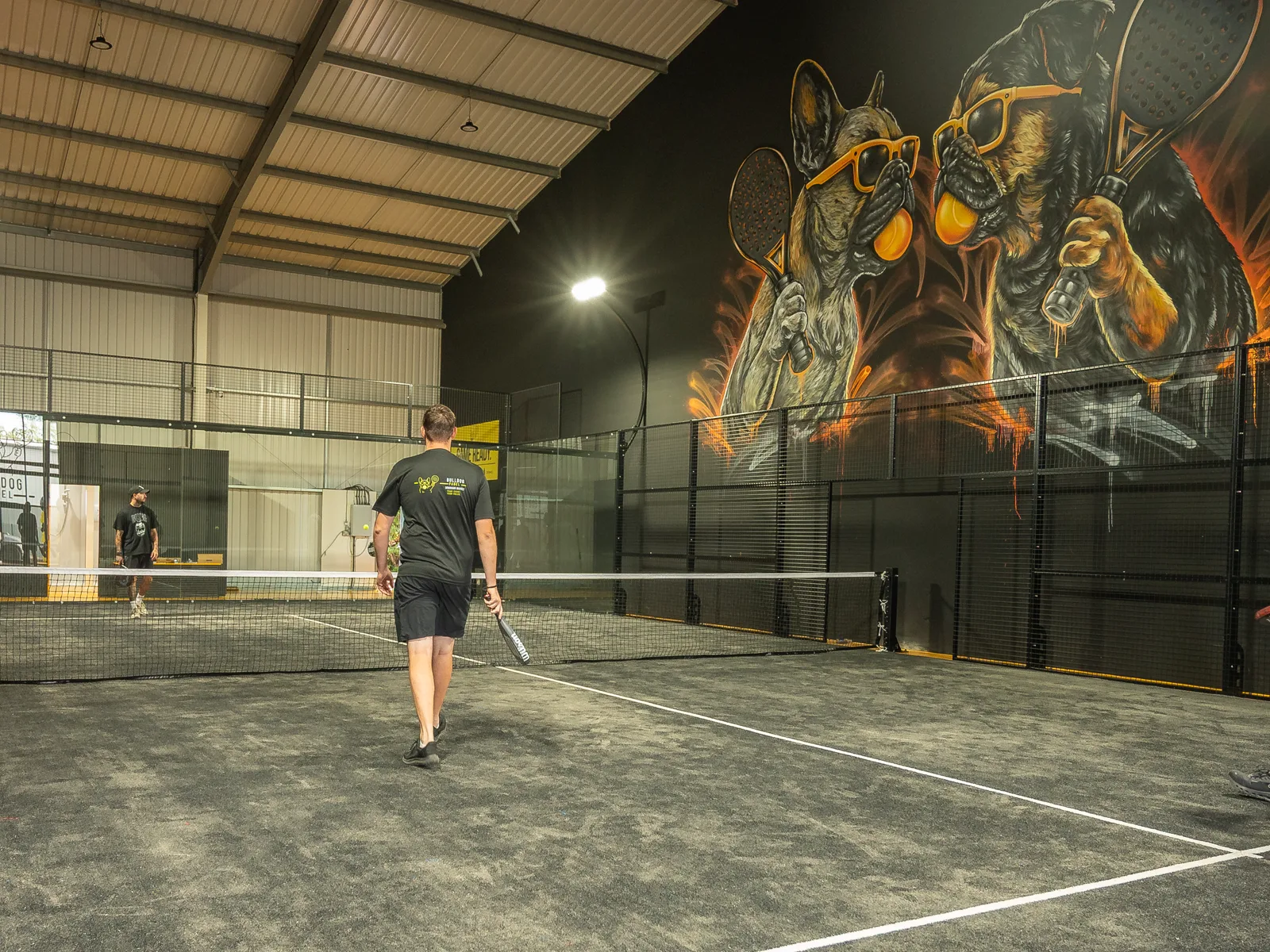 Launch-day action beneath the Bulldog Padel mural
